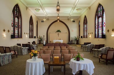 Interior view of a chapel with colorful stained glass windows