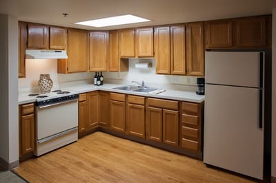Well-lit kitchen area with wooden cabinets