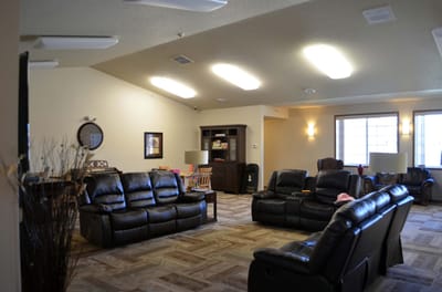 Common area with black leather couches and wooden furniture