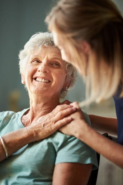 Smiling resident enjoying conversation with staff member.