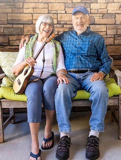 Two residents enjoying music on a bench