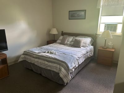 Cozy bedroom with a bed, nightstands, and TV