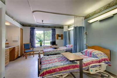 Shared resident room with two beds and seating area