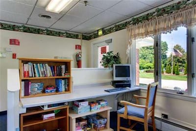 Common area with bookshelves and seating near a window