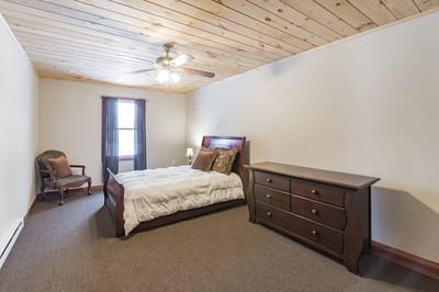 Cozy bedroom with wooden ceiling and modern furniture