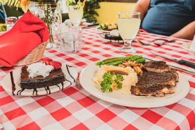 A plate of steak, mashed potatoes, and dessert on a dining table