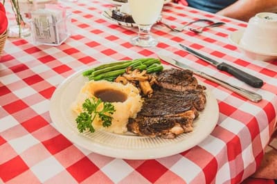 A plated meal with steak, mashed potatoes, and green beans