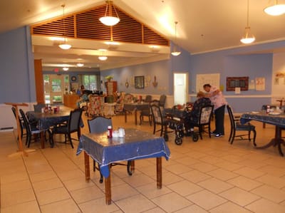 Residents interacting in a dining area with tables and chairs