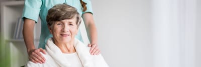 Senior resident smiling with caregiver behind her