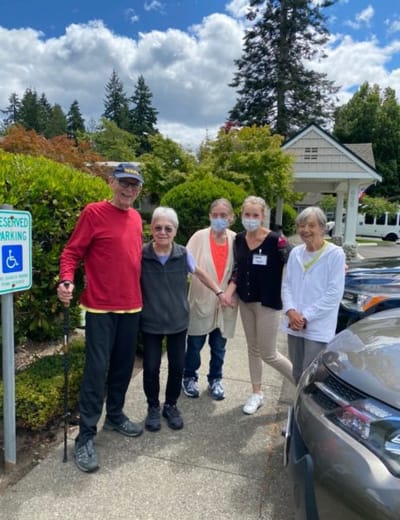 Residents and staff outside in a sunny area
