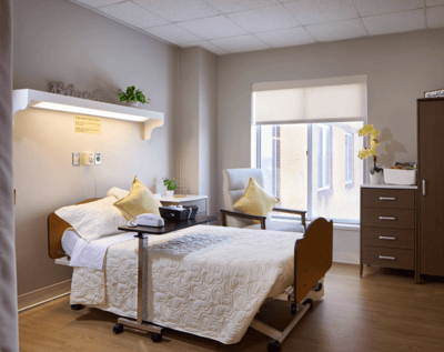 Bright, comfortable resident room with a bed and chair