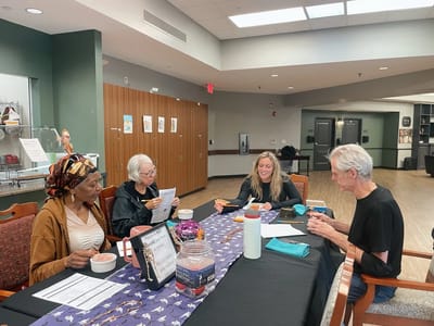 Residents and staff engaged in a dining activity
