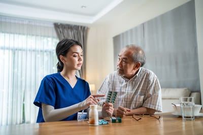Medical staff assisting an elderly man with medication