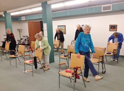Residents participating in a seated exercise class