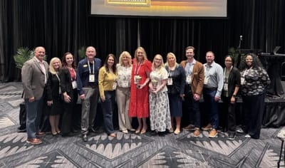 Group of staff members celebrating an award in a conference room
