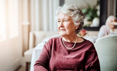 Portrait of a thoughtful elderly woman in a cozy interior