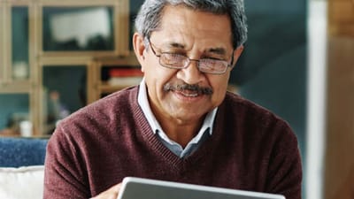 Senior man using a tablet and smiling