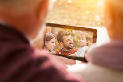 Seniors looking at a tablet showing a family photo