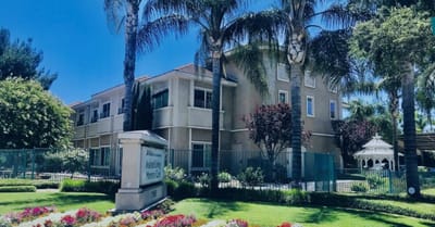 Exterior view of a senior living facility with gardens