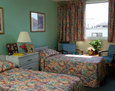 Private resident room with two beds and decor