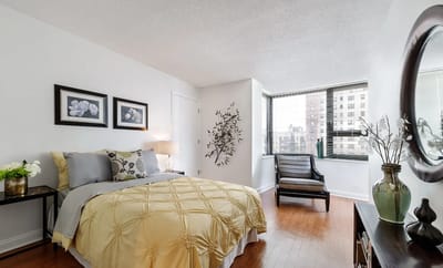 Brightly decorated private resident room with a bed and seating area