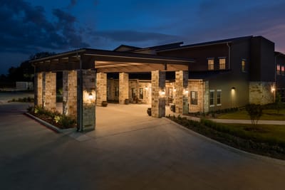 Exterior view of the Spring Cypress Senior Living entrance at dusk