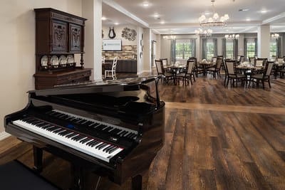Interior view of a dining room with a piano and tables