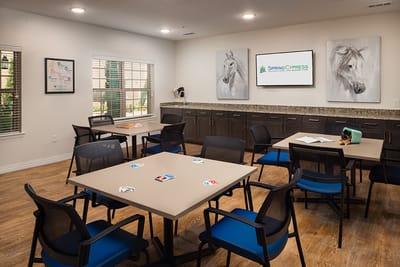 Bright common area with tables and horse paintings