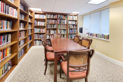 Interior view of a library with bookshelves and a table
