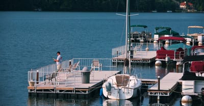 A man fishing at a lakeside dock
