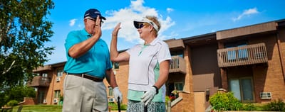 Two residents enjoying a sunny day outdoors at the facility.