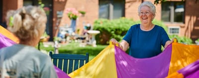 Residents playing with colorful fabric in an outdoor space