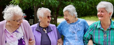 Four smiling women enjoying each other's company outdoors