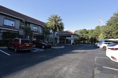 Building exterior with parking area and palm trees