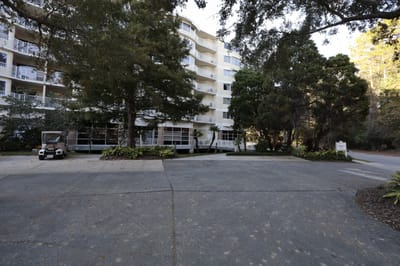 The exterior view of Cypress Village with trees and walkway