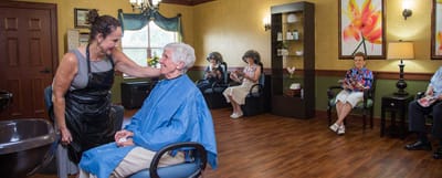 Residents enjoying a salon activity with staff in a cozy space