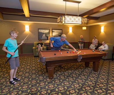 Seniors playing billiards in a common area