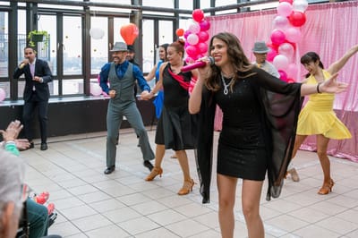 Residents enjoying a lively performance in a common area