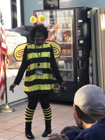Staff member in a bee costume entertaining residents