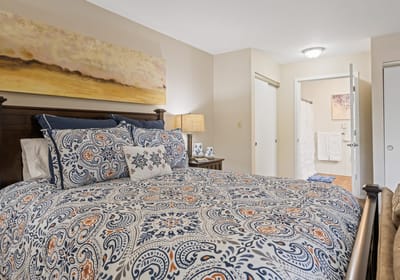 Cozy resident bedroom with decorative bedding and lamp