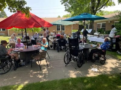 Residents enjoying a gathering outside under umbrellas