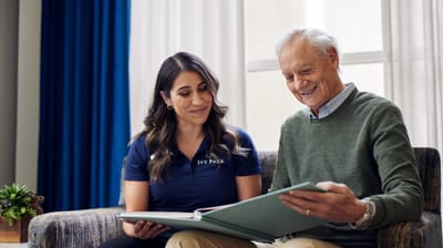 Staff member reading with a resident in a cozy setting
