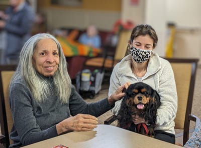 Residents enjoying time together with a dog in a common area