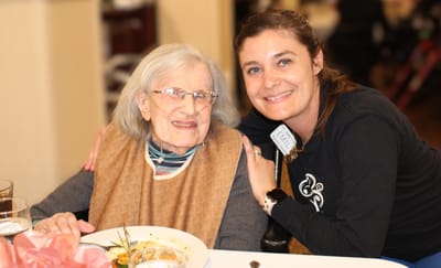 Resident enjoying a meal with staff member