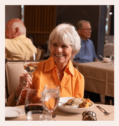 Acacia Health Center at Sagewood, Nursing Home in Phoenix, AZ — Smiling woman in orange shirt raising a wine glass