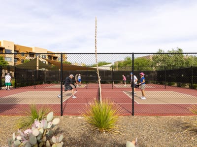 Residents playing pickleball in an outdoor court