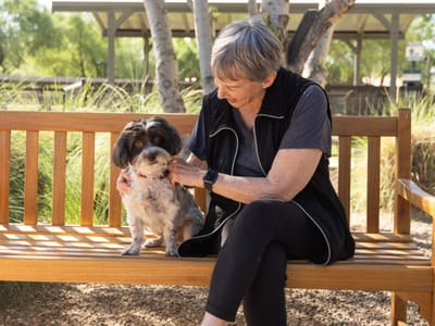 Acacia Health Center at Sagewood, Nursing Home in Phoenix, AZ — Woman seated on a bench with a small dog