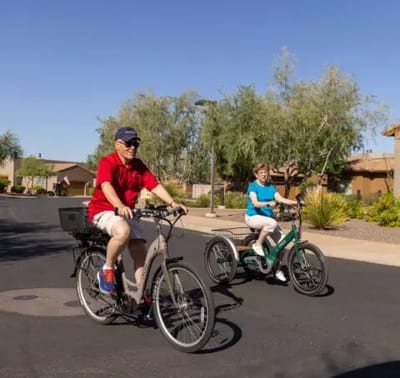Acacia Health Center at Sagewood, Nursing Home in Phoenix, AZ — Seniors riding electric bikes on a sunny pathway