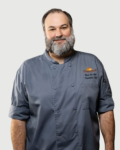Acacia Health Center at Sagewood, Nursing Home in Phoenix, AZ — Chef in a gray uniform with a friendly smile