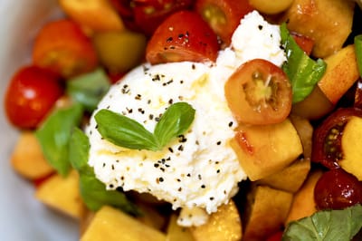 Colorful fruit salad with cheese and basil